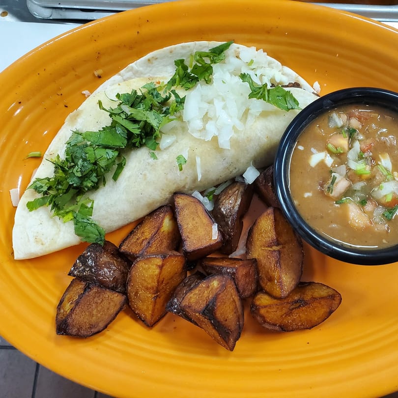 Mexican burrito with cilantro and onions, roasted potatoes, and a side of bean soup.